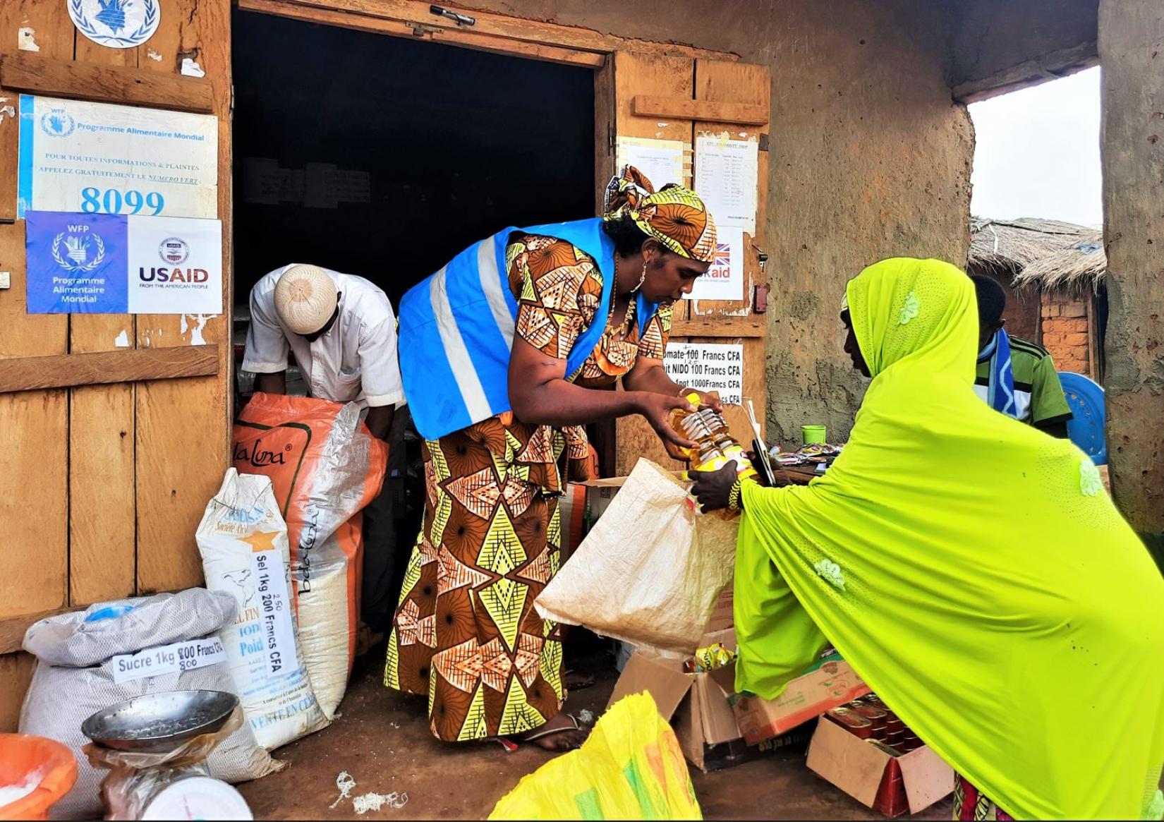 Houreiratou Bello, serving another refugee Cash assistance beneficiary in her Borgop shop    