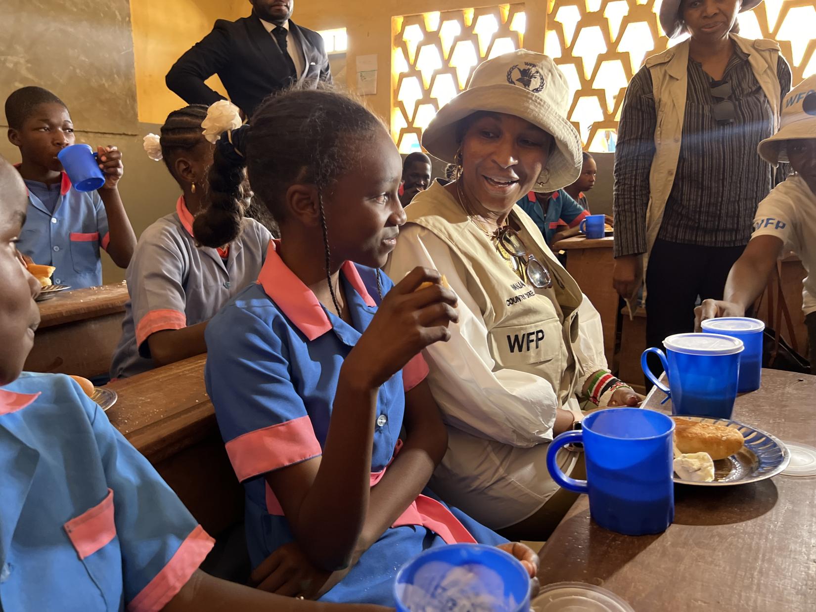 WFP Country Director Wanja Kaaria, wearing a WFP cap, interacts with a girl student at Beka Matali School in Ngaoundere