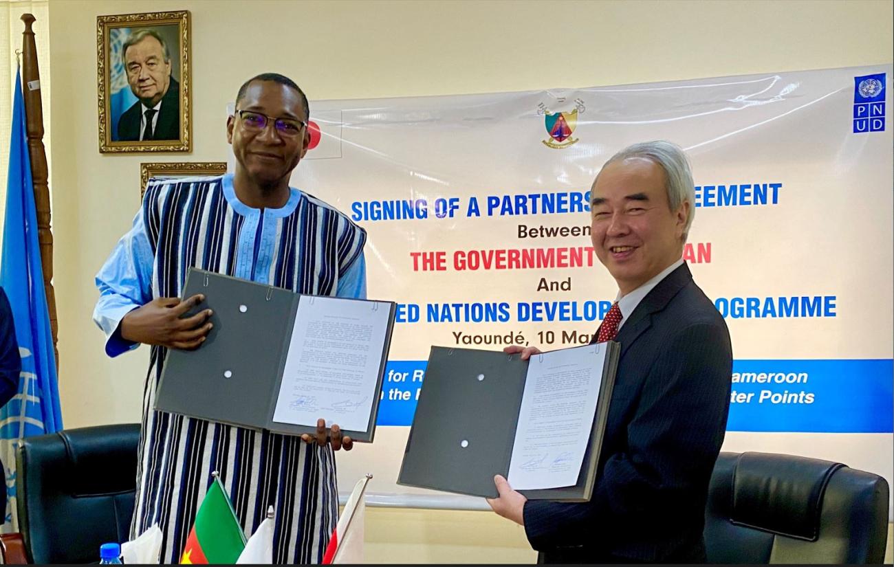 UNDP Cameroon’s Acting Resident Representative, Alassane Ba, and the Ambassador of Japan to Cameroon, H.E. Mr. TAKAOKA Nozomu presenting the signed agreement, during the ceremony. 